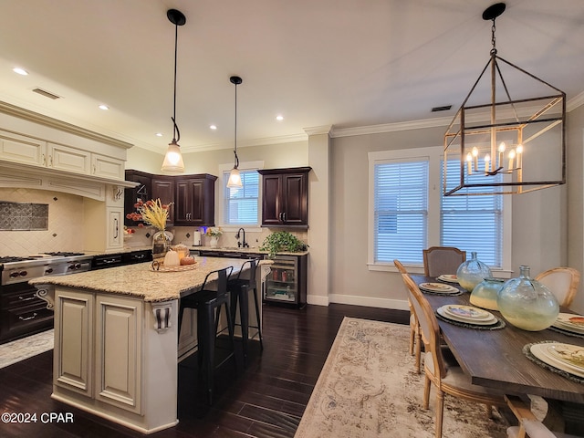 kitchen with dark hardwood / wood-style floors, backsplash, sink, a center island, and pendant lighting