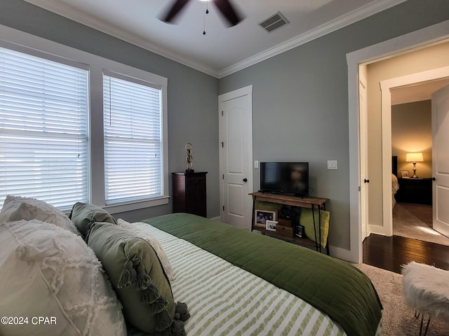 bedroom featuring ceiling fan, ornamental molding, and hardwood / wood-style floors