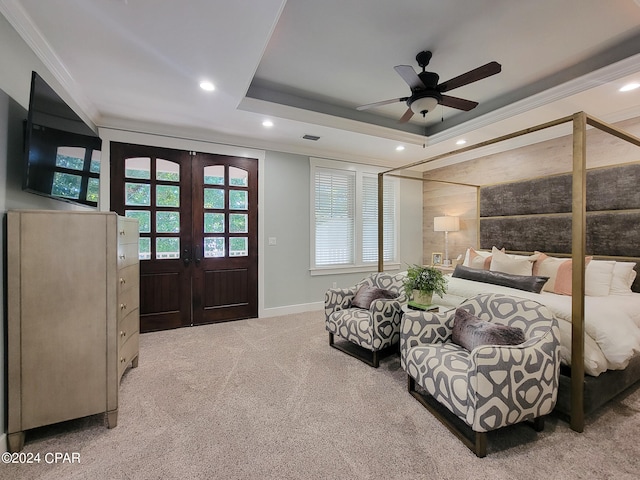 carpeted bedroom featuring french doors, ceiling fan, crown molding, and a tray ceiling