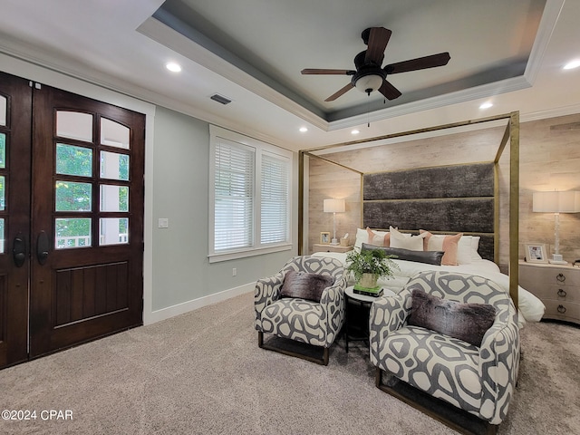 carpeted bedroom with ornamental molding, a tray ceiling, and ceiling fan