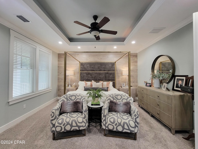 carpeted bedroom featuring ornamental molding, a tray ceiling, and ceiling fan