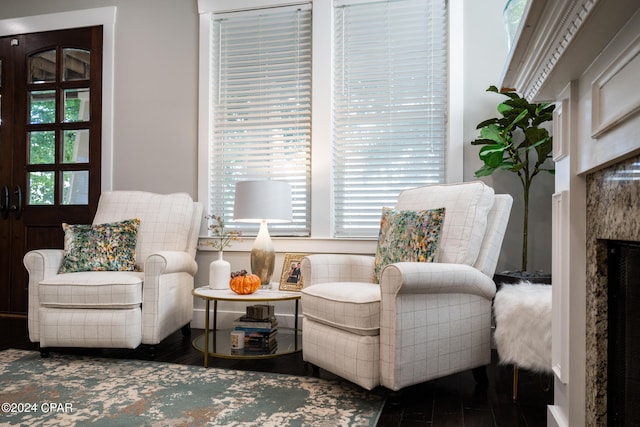 sitting room featuring a premium fireplace and dark wood-type flooring