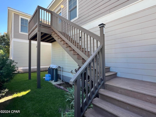 view of side of home featuring a wooden deck and a lawn