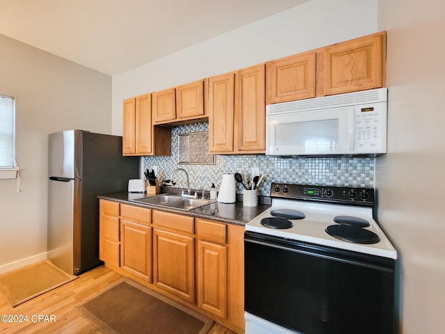 kitchen with white appliances, light hardwood / wood-style flooring, tasteful backsplash, and sink