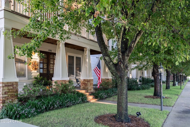 property entrance with a yard and a balcony