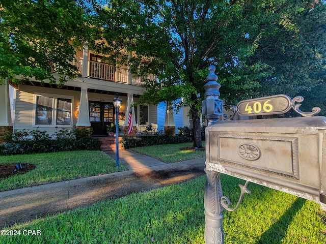 view of front facade featuring a front yard and a balcony