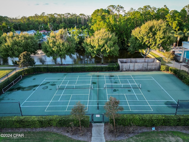 view of tennis court with a water view