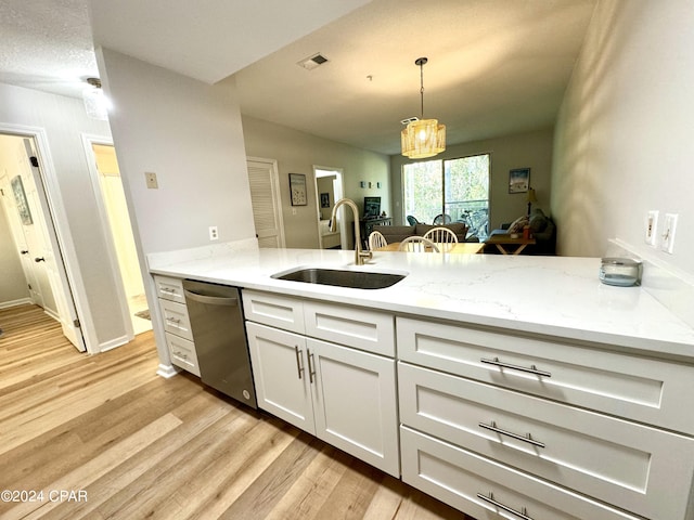 kitchen with white cabinetry, light stone countertops, light wood-type flooring, dishwasher, and sink