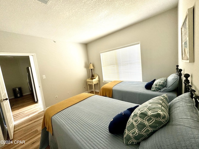 bedroom with hardwood / wood-style floors and a textured ceiling