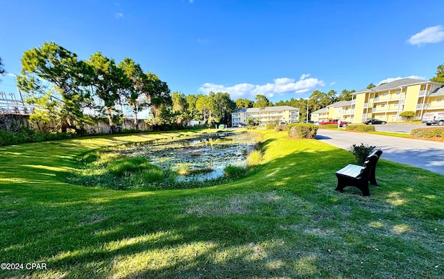 view of community with a yard and a water view