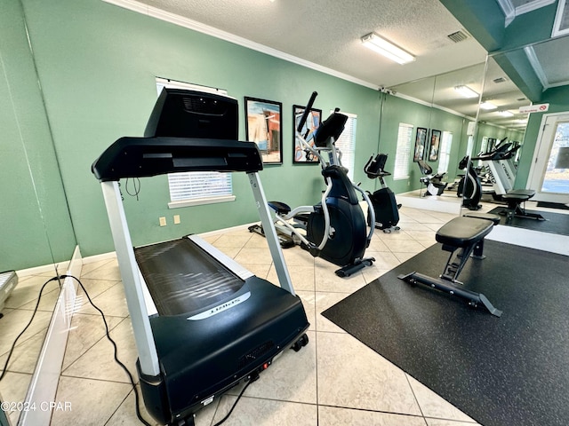 gym with ornamental molding, a textured ceiling, and tile patterned flooring