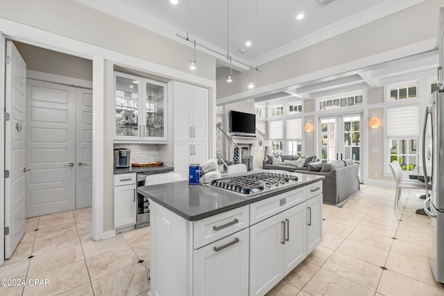 kitchen with decorative backsplash, appliances with stainless steel finishes, ornamental molding, beverage cooler, and white cabinetry