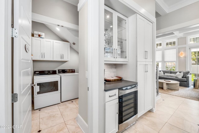 kitchen featuring wine cooler, crown molding, white cabinets, and independent washer and dryer