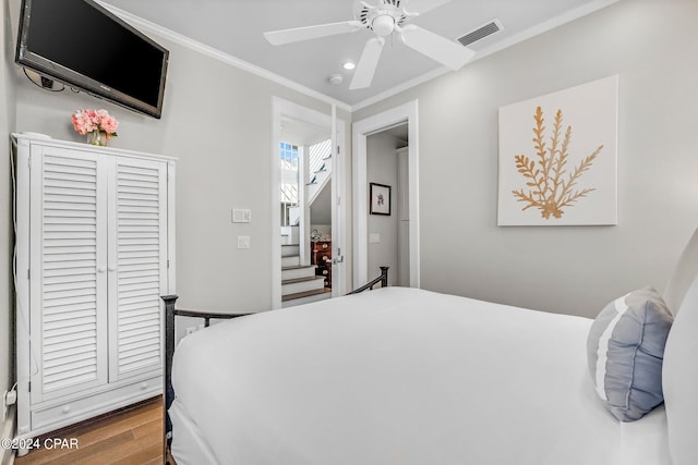 bedroom featuring ceiling fan, ornamental molding, and hardwood / wood-style flooring