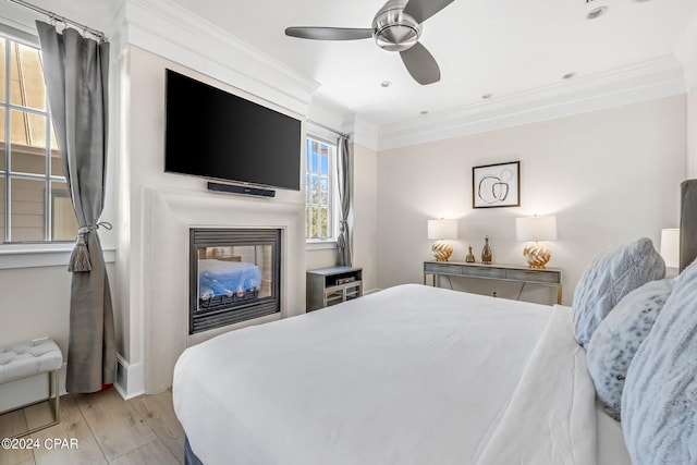 bedroom featuring ceiling fan, light hardwood / wood-style floors, and ornamental molding