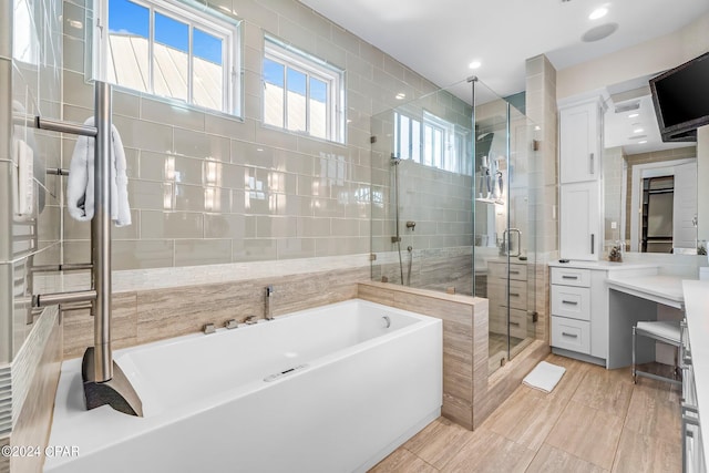 bathroom featuring a wealth of natural light, vanity, tile walls, and shower with separate bathtub