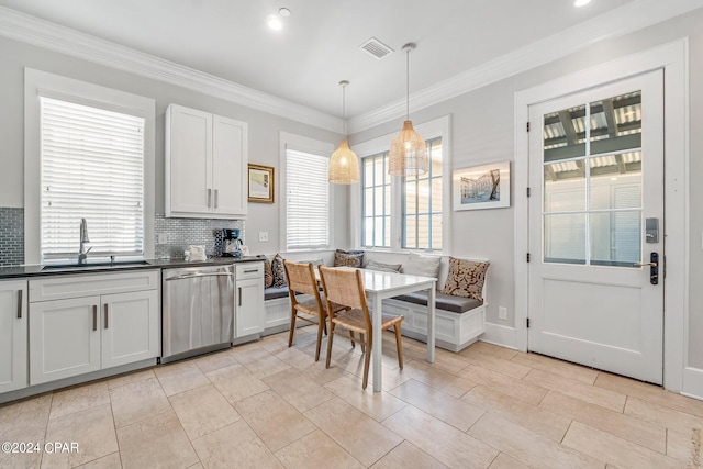 kitchen with backsplash, white cabinets, sink, decorative light fixtures, and dishwasher