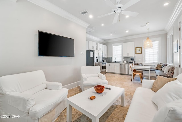 living room with ceiling fan, ornamental molding, and sink