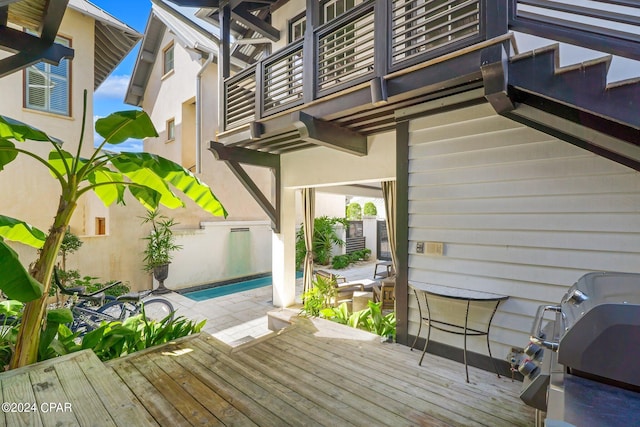 deck featuring area for grilling and a pool