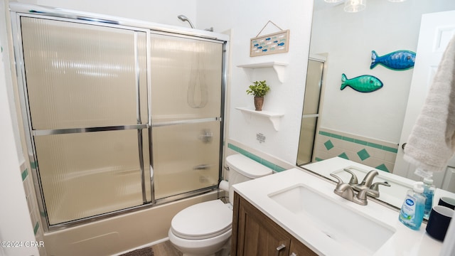 full bathroom featuring vanity, toilet, and shower / bath combination with glass door