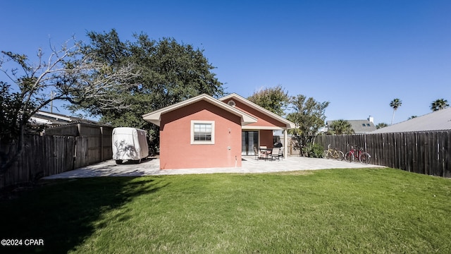 rear view of property featuring a patio and a lawn