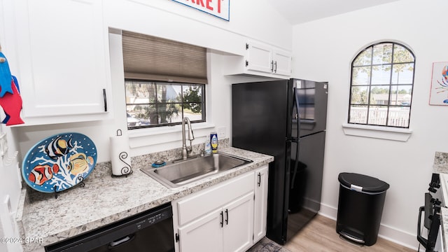 kitchen featuring light hardwood / wood-style flooring, white cabinetry, sink, and a wealth of natural light