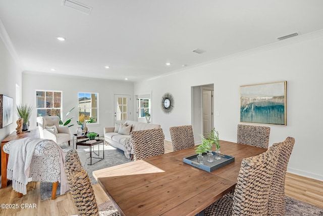 dining area featuring ornamental molding and light hardwood / wood-style floors