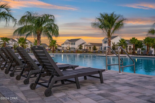 pool at dusk with a patio area