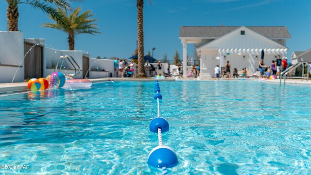 view of pool with a water slide and a pergola