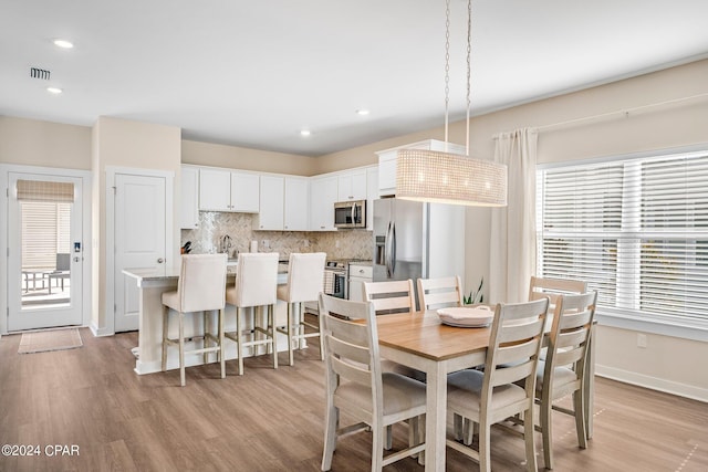 dining room with a wealth of natural light and light wood-type flooring