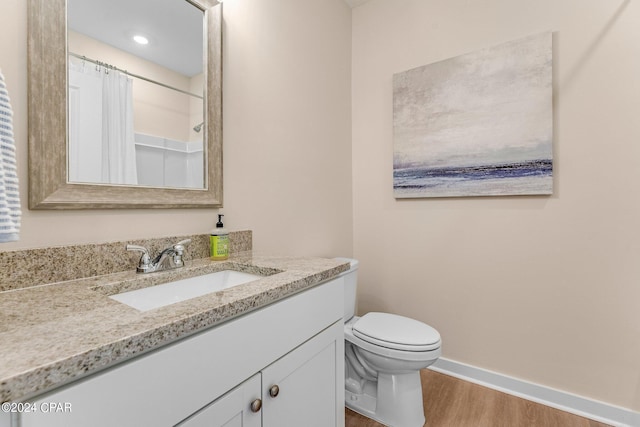 bathroom featuring vanity, hardwood / wood-style floors, and toilet