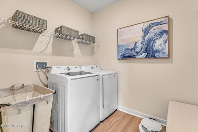 laundry area with separate washer and dryer and light wood-type flooring