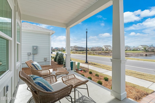 view of patio / terrace featuring a water view and covered porch