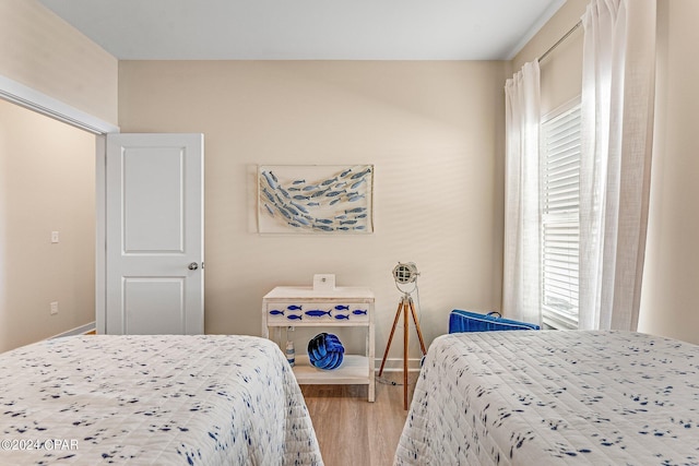 bedroom with wood-type flooring and multiple windows