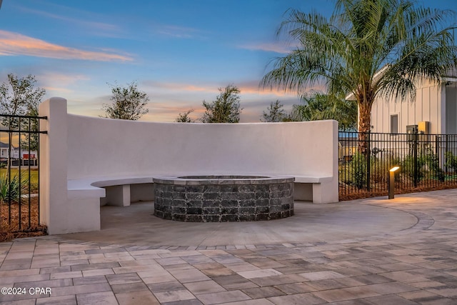 patio terrace at dusk featuring an outdoor fire pit