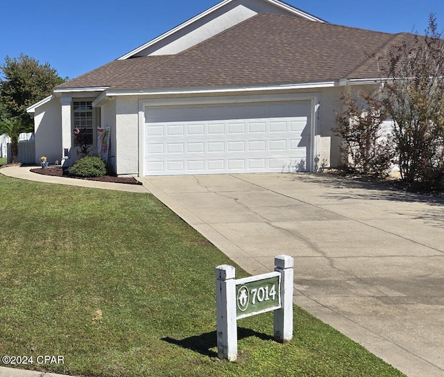 view of front of home featuring a front yard and a garage