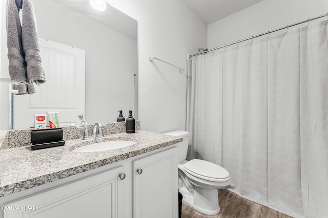 bathroom with vanity, hardwood / wood-style floors, toilet, and walk in shower