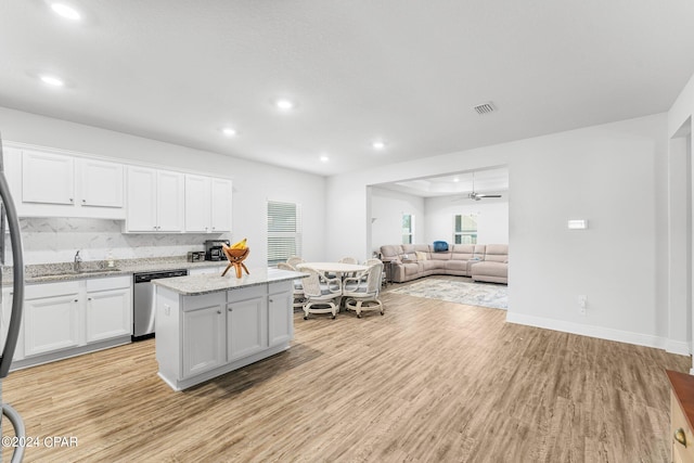 kitchen featuring appliances with stainless steel finishes, white cabinetry, light wood-type flooring, and a kitchen island