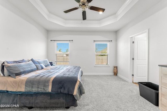 carpeted bedroom featuring crown molding, a tray ceiling, and ceiling fan