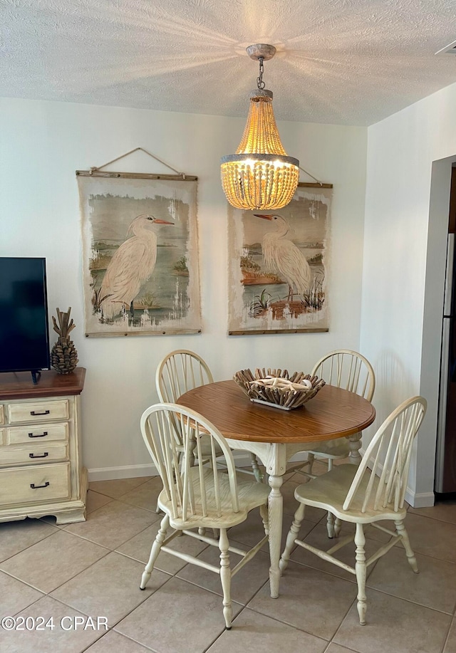 dining space featuring a textured ceiling and light tile patterned floors