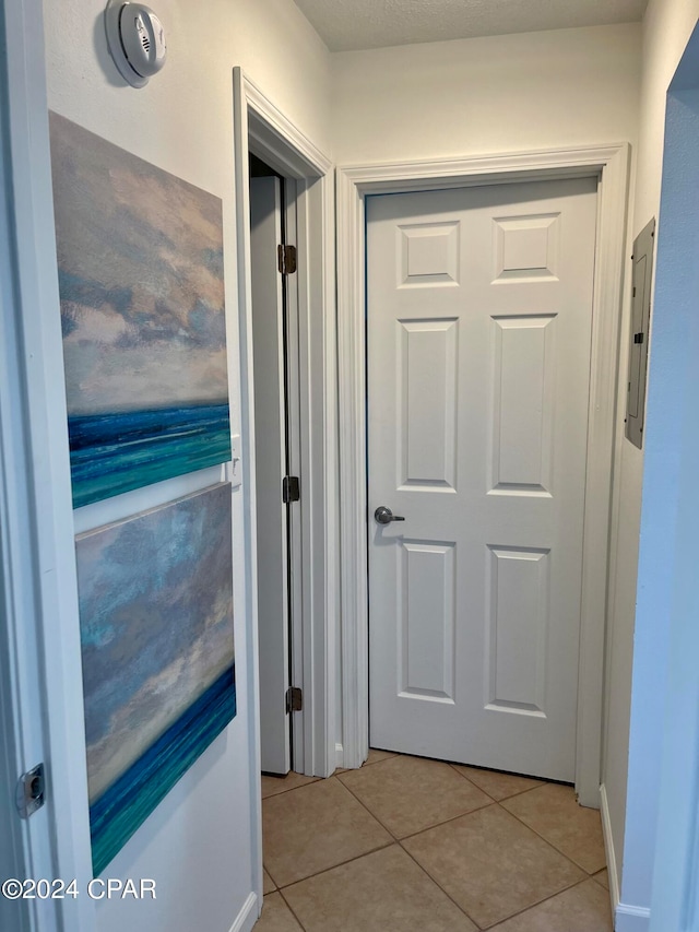 hall with electric panel and light tile patterned flooring