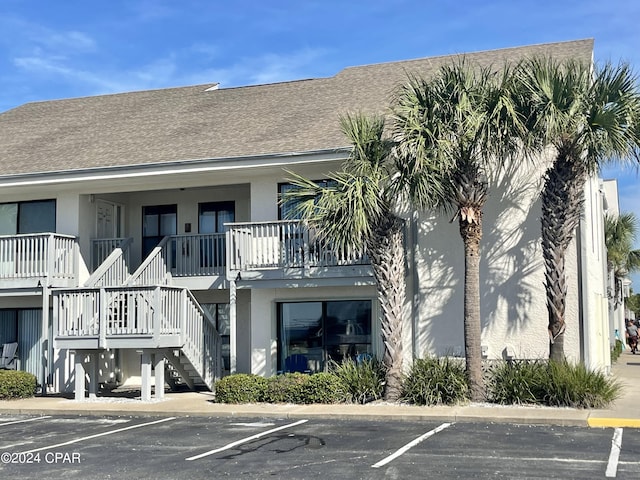 view of building exterior featuring uncovered parking and stairway