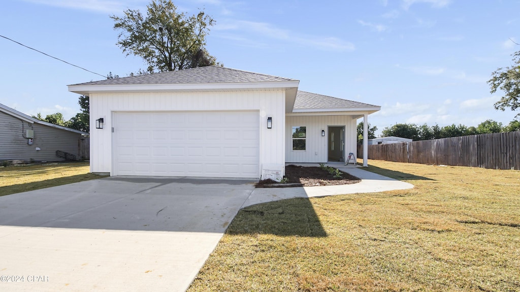 view of front of home with a front yard and a garage