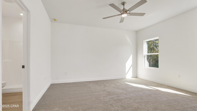 empty room featuring a ceiling fan, baseboards, and carpet floors
