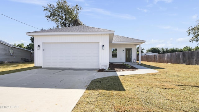 view of front of house featuring fence, roof with shingles, a front lawn, concrete driveway, and a garage