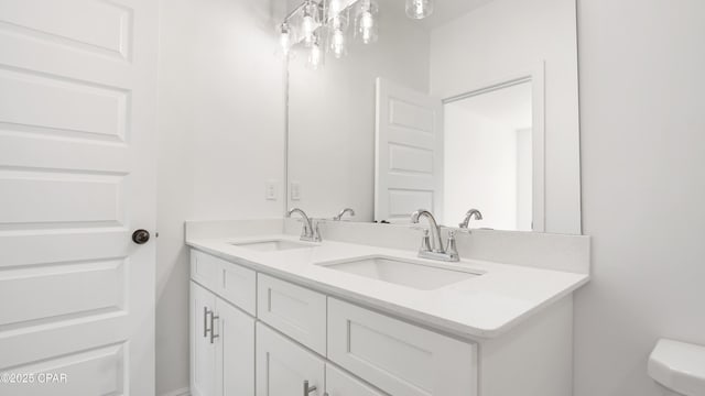 bathroom featuring double vanity, toilet, and a sink