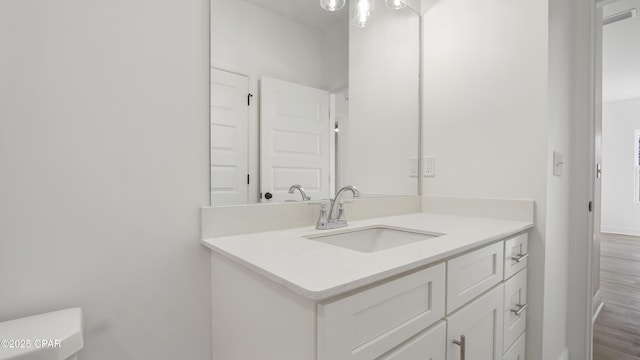 bathroom featuring vanity, baseboards, and wood finished floors