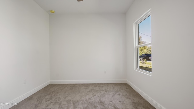 unfurnished room with a ceiling fan, carpet, and baseboards