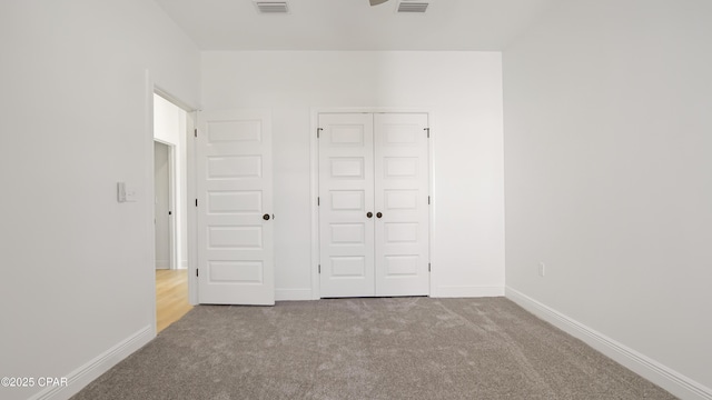 unfurnished bedroom featuring a closet, carpet flooring, visible vents, and baseboards