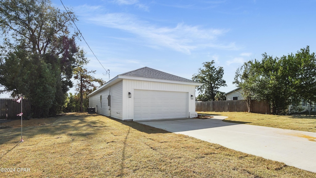 view of side of home featuring a lawn and a garage